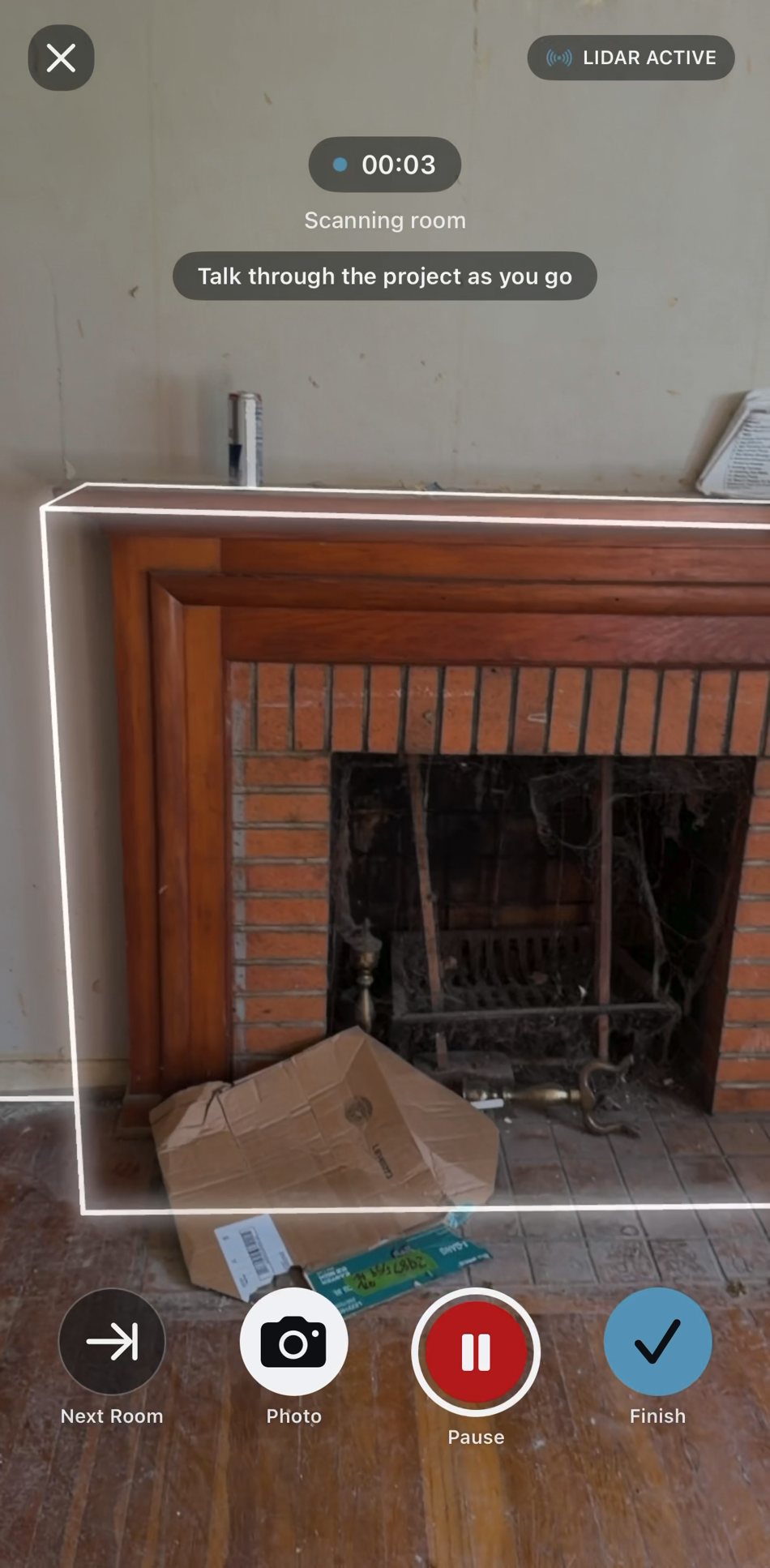 Live room scan mid-capture with white measurement lines traced along a fireplace wall